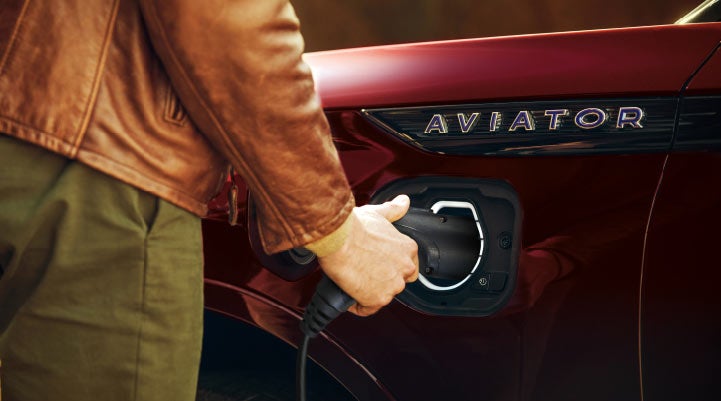 A hand is shown plugging in the charger into the charging port of a 2021 Lincoln Aviator | Bill Knight Lincoln in Tulsa OK