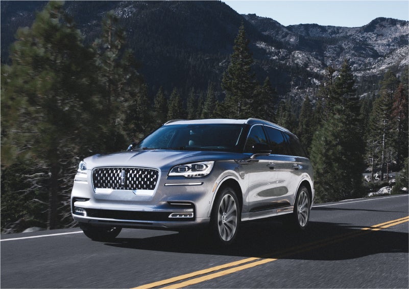 A 2023 Lincoln Aviator® Grand Touring SUV being driven on a winding road to demonstrate the capabilities of all-wheel drive | Bill Knight Lincoln in Tulsa OK