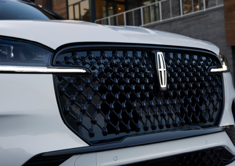 The black grille of a white 2025 Lincoln Aviator® SUV is shown with its fog lights on. | Bill Knight Lincoln in Tulsa OK