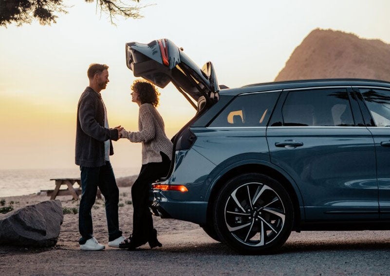 A couple share a moment together outside a 2025 Lincoln Corsair® SUV near the open liftgate. | Bill Knight Lincoln in Tulsa OK