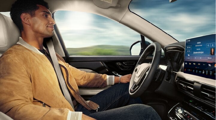 A person is shown using Lincoln BlueCruise hands-free highway driving technology on a divided highway called a Hands-Free Blue Zone. | Bill Knight Lincoln in Tulsa OK
