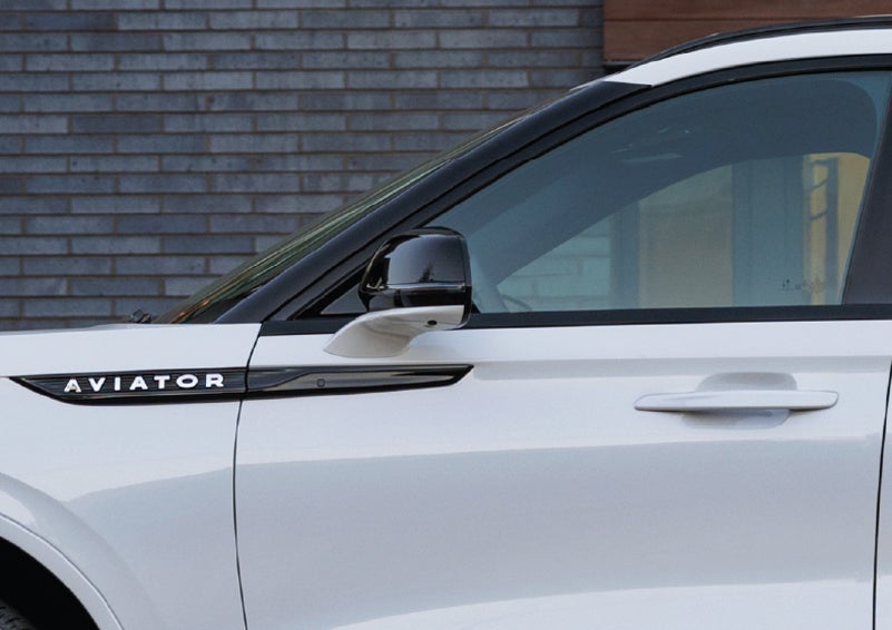 The driver’s side door and fender badging of a white 2026 Lincoln Aviator® SUV are showcased. | Bill Knight Lincoln in Tulsa OK