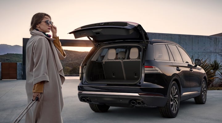 A woman approaches a 2026 Lincoln Aviator® SUV with its rear liftgate open. | Bill Knight Lincoln in Tulsa OK
