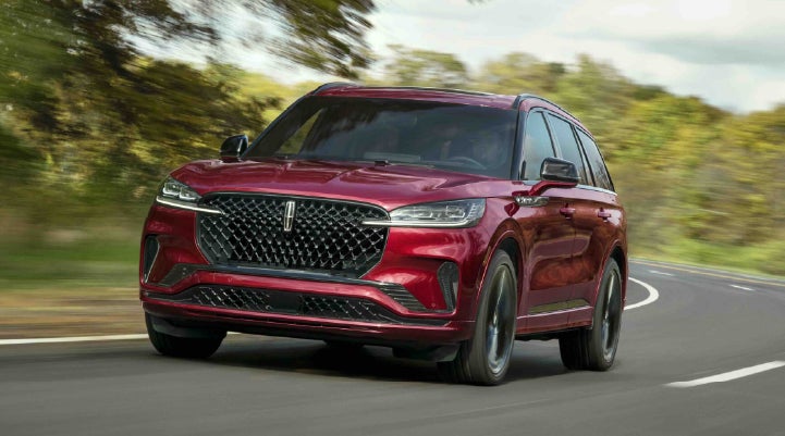 A 2027 Lincoln Aviator® SUV is being driven on a country road | Bill Knight Lincoln in Tulsa OK